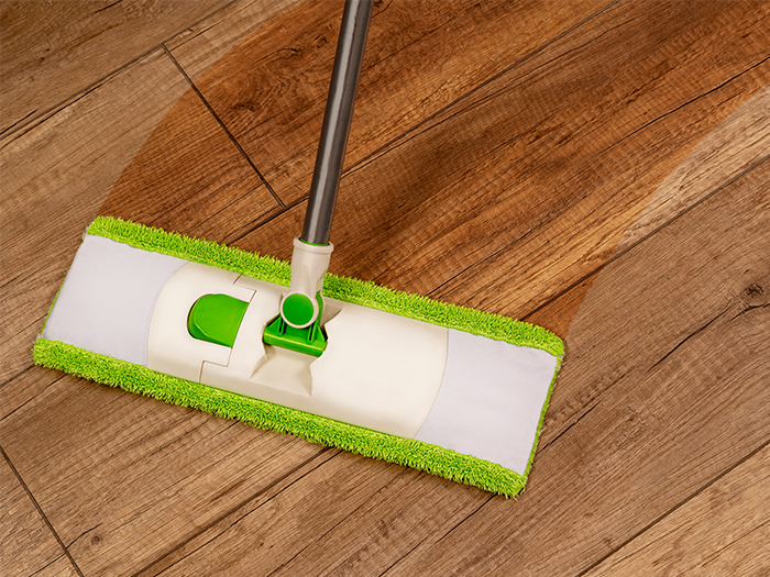 Bodenwischer reinigt einen Laminatboden in der Wohnung.
